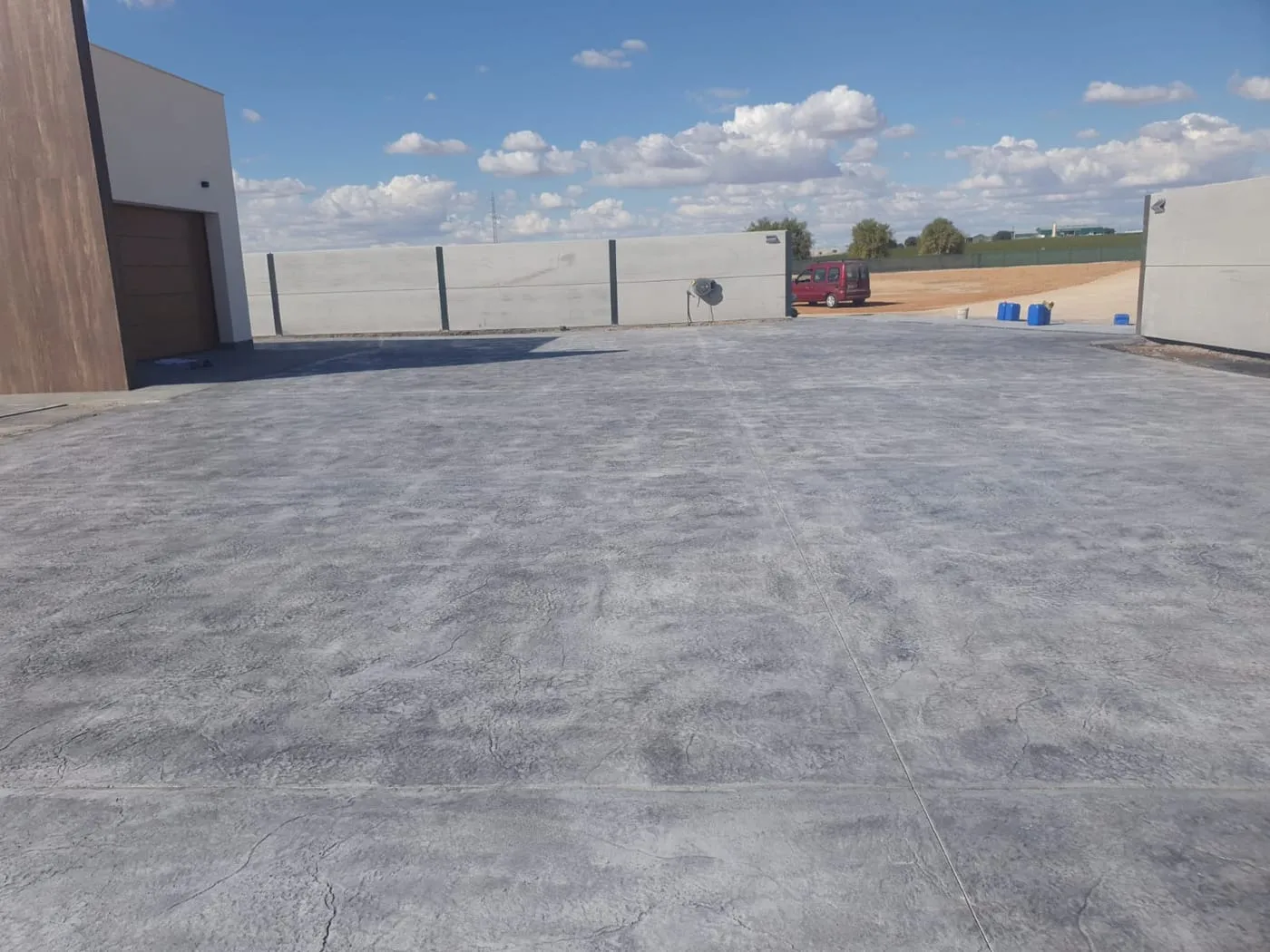 Entrada de garaje de hormigón impreso gris en una vivienda nueva