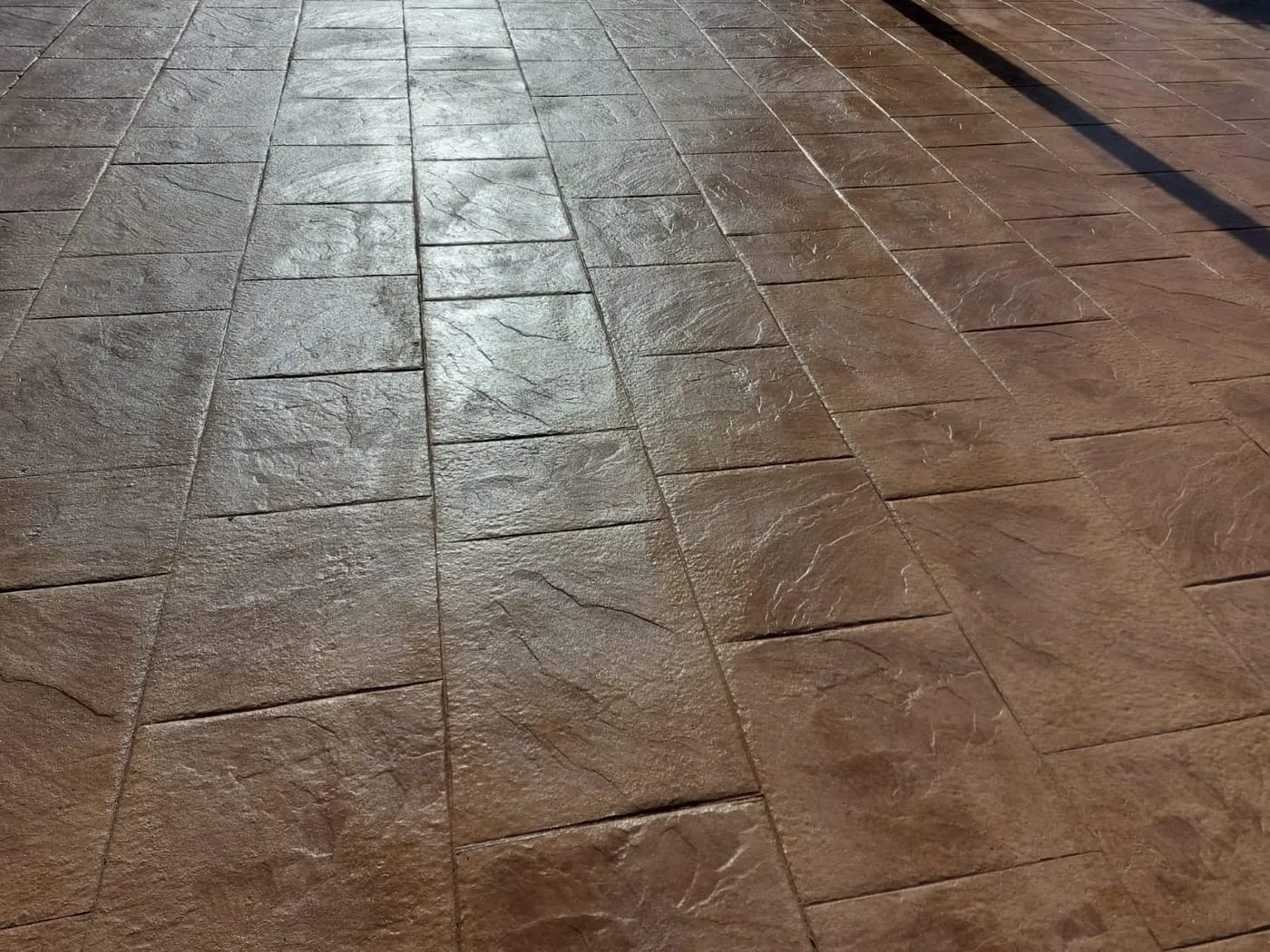Detalle de hormigón impreso con molde de losa de piedra en tono terracota