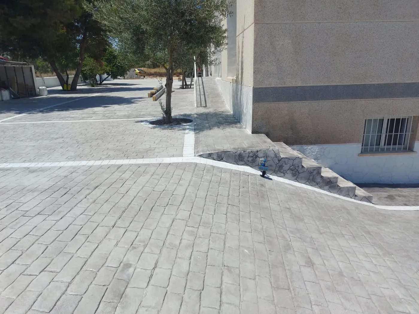 Rampa de acceso junto a una vivienda en hormigón impreso de adoquín