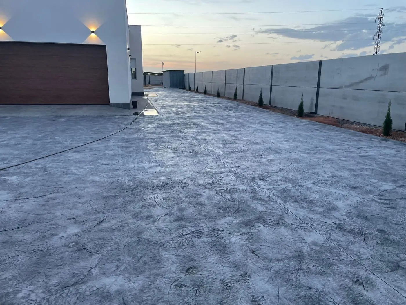 Entrada de garaje de hormigón impreso gris en una vivienda unifamiliar