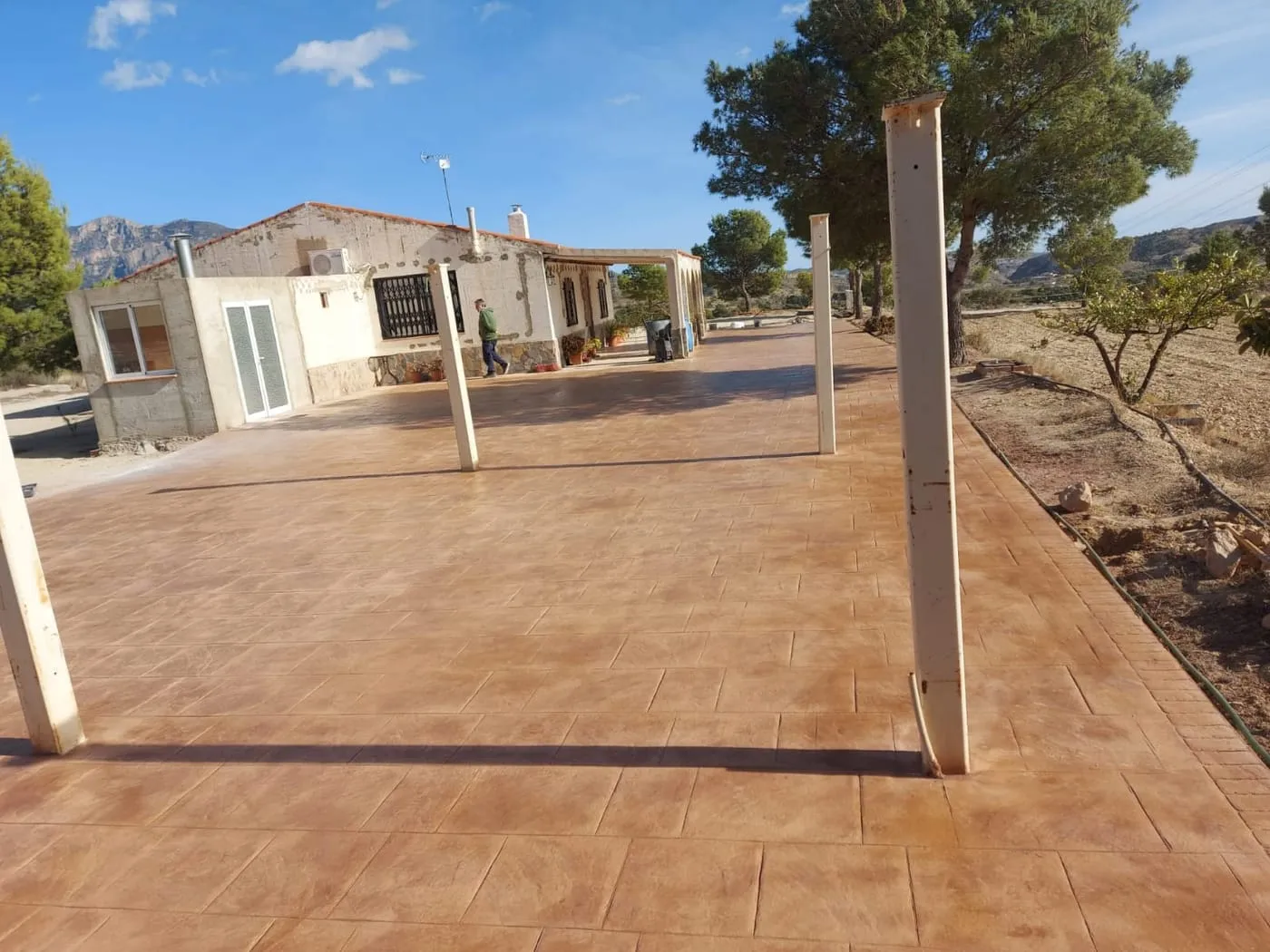 Porche de una casa de campo pavimentado con hormigón impreso en color terracota