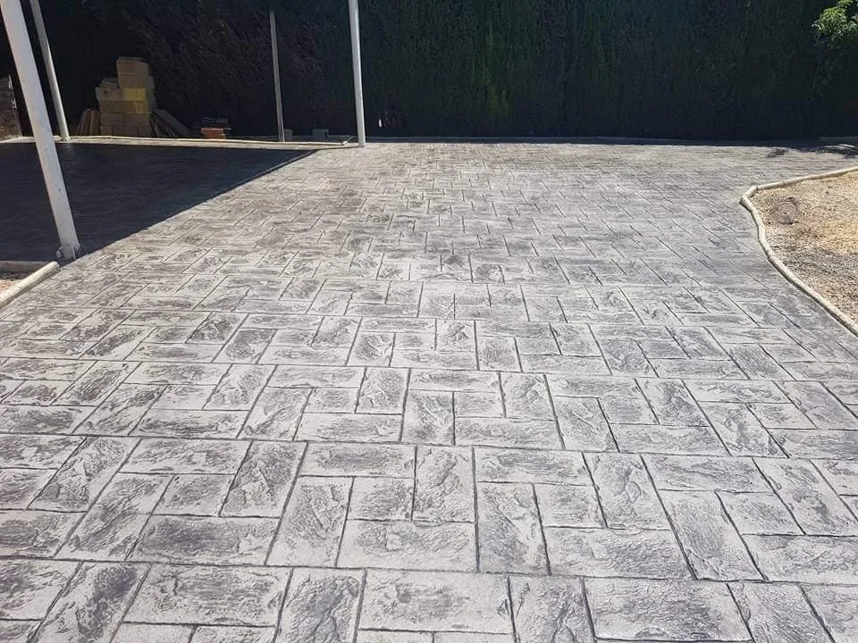 Patio de hormigón impreso gris con el brillo de la resina de sellado recién aplicada