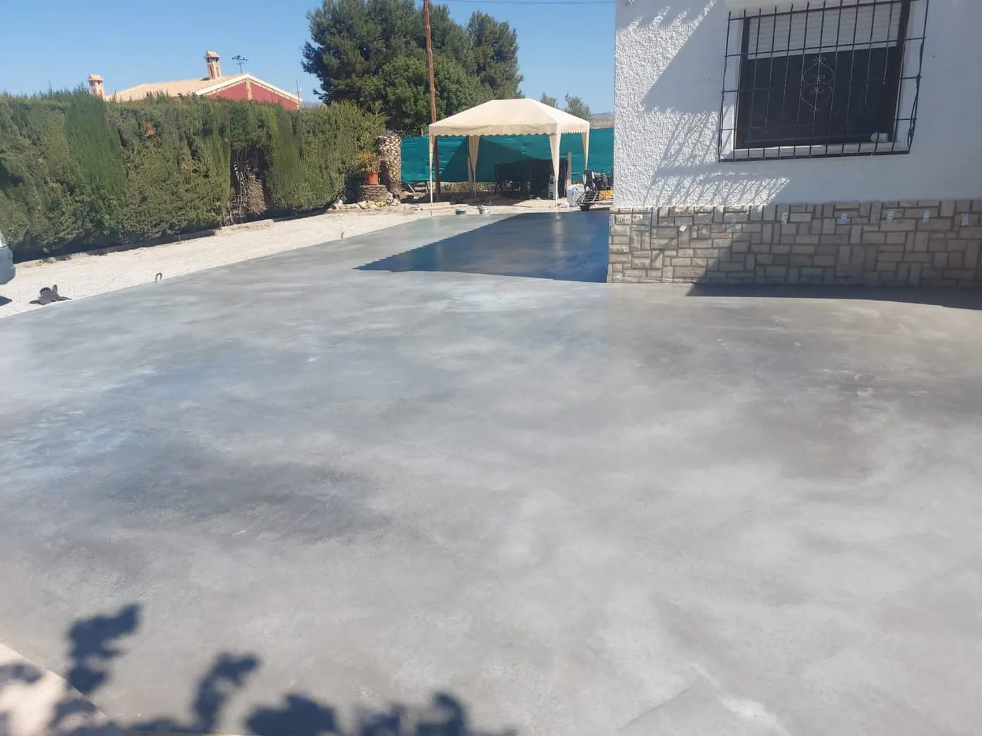 Solera de hormigón liso y continuo delante de una vivienda