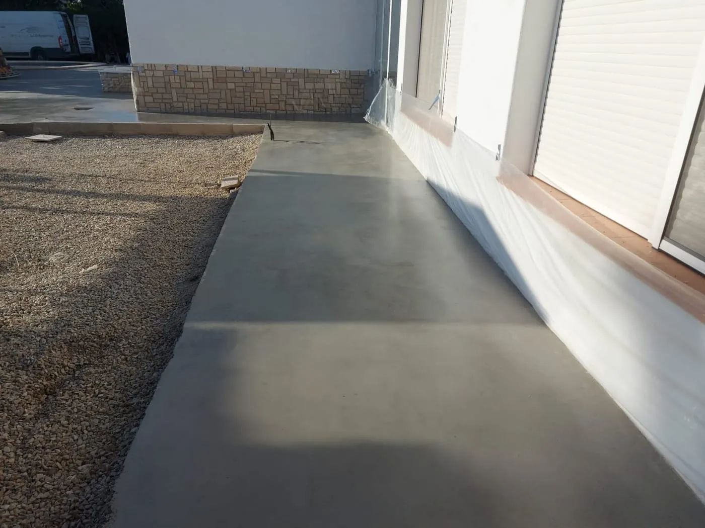 Solera de hormigón fratasado a lo largo de la fachada de una vivienda